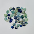 Assorted blue and green gemstones on a white background