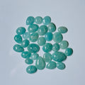 Teal teardrop-shaped gemstones on a light blue background
