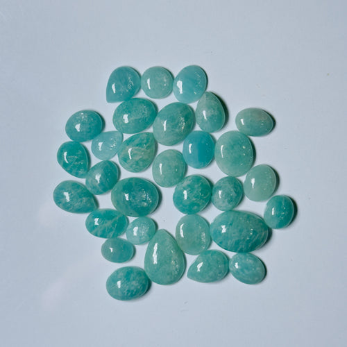 Teal teardrop-shaped gemstones on a light blue background