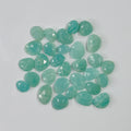 Teal gemstones on a light gray background