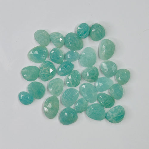 Teal gemstones on a light gray background
