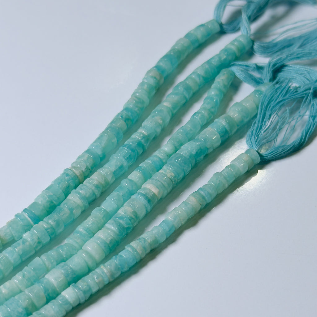 Turquoise beads on a string against a light background