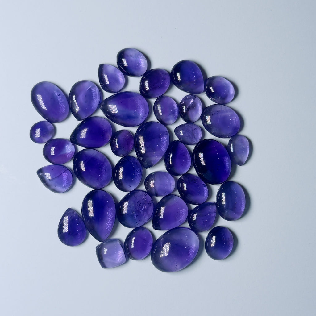 Purple teardrop-shaped stones on a light gray background
