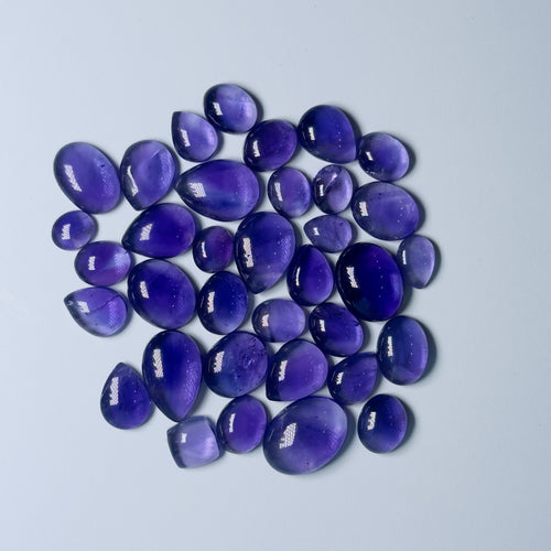 Purple teardrop-shaped stones on a light gray background