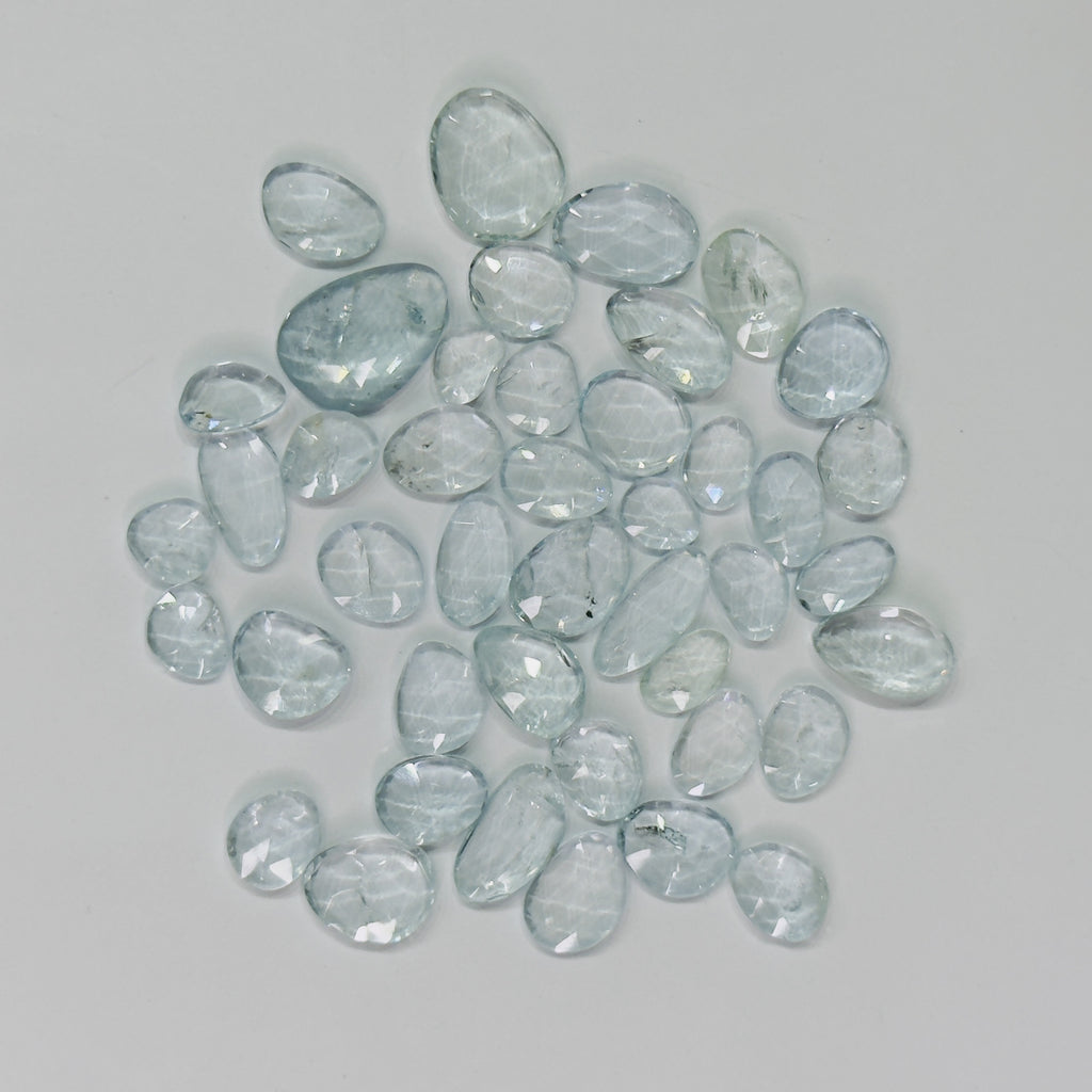 Collection of light blue gemstones on a gray background
