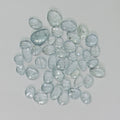 Collection of light blue gemstones on a gray background