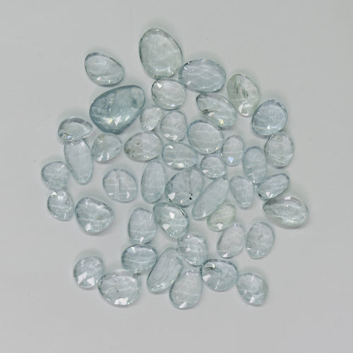 Collection of light blue gemstones on a gray background