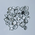 Collection of clear gemstones with black inclusions on a White background