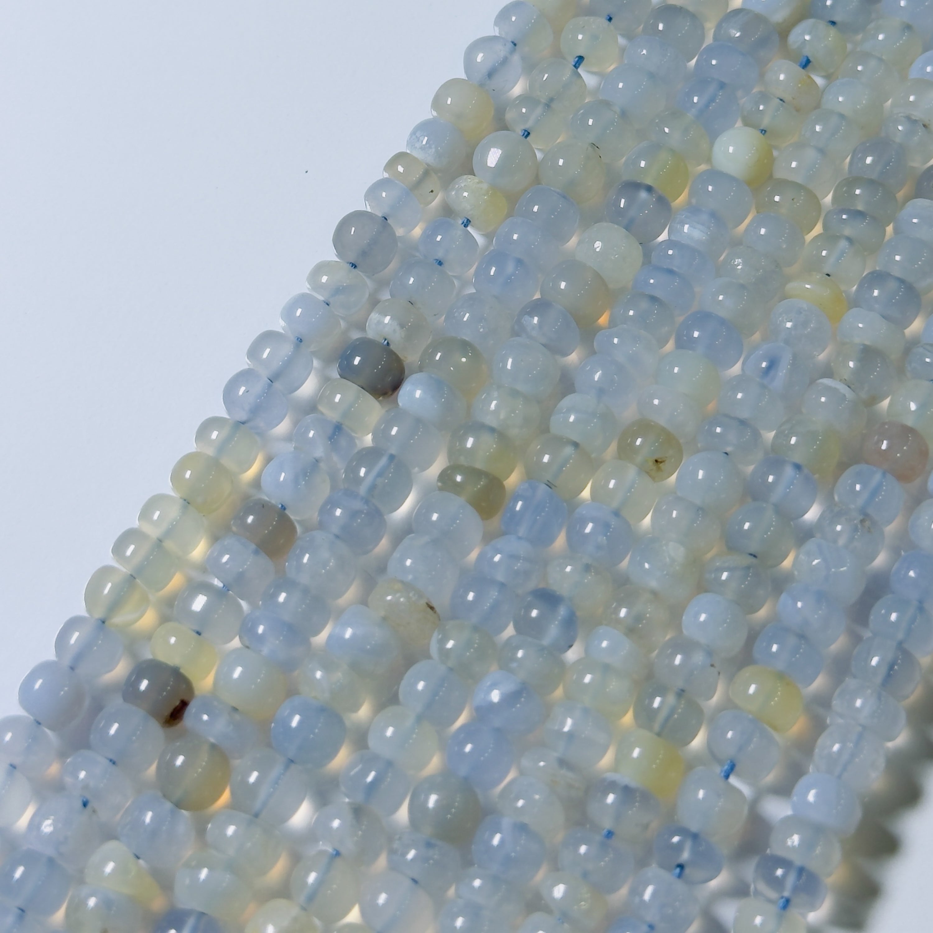 Close-up of a string of light blue and gray beads on a white background