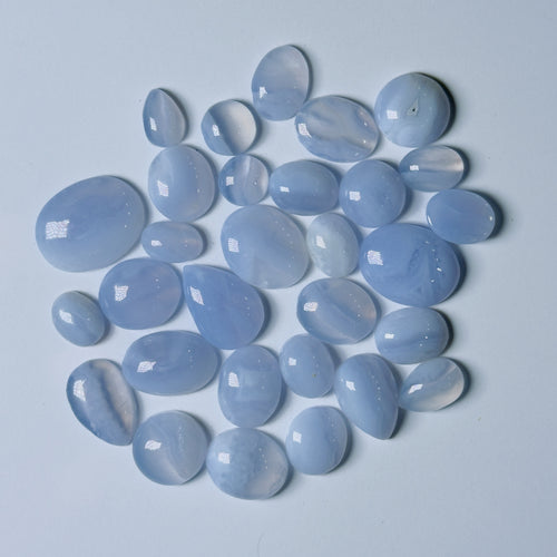 Collection of light blue stones on a light gray background