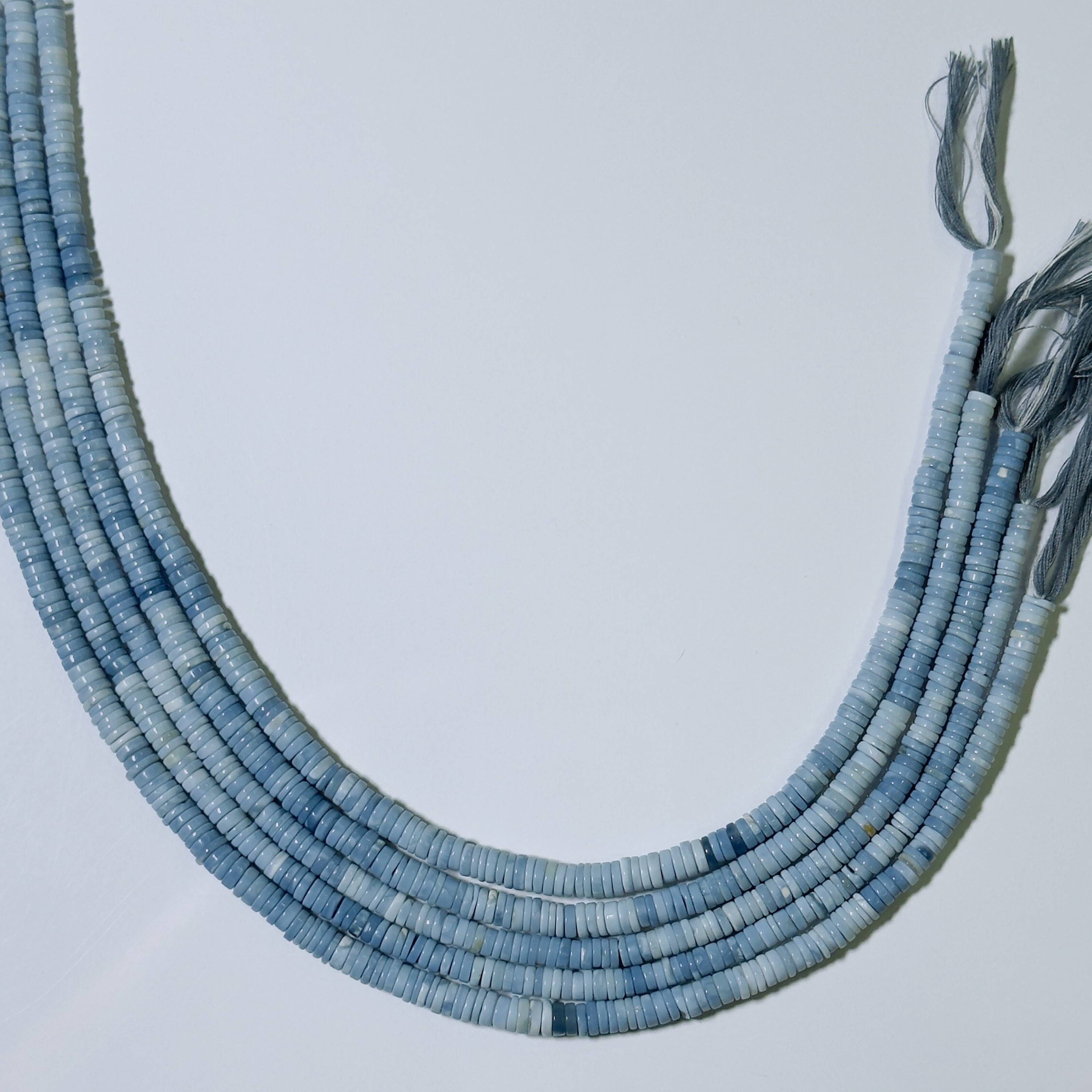 Blue beaded necklace on a light gray background