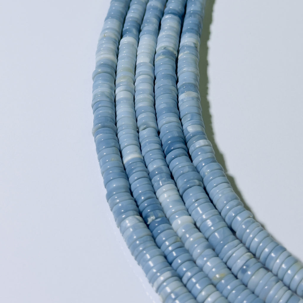 String of light blue beads on a white background