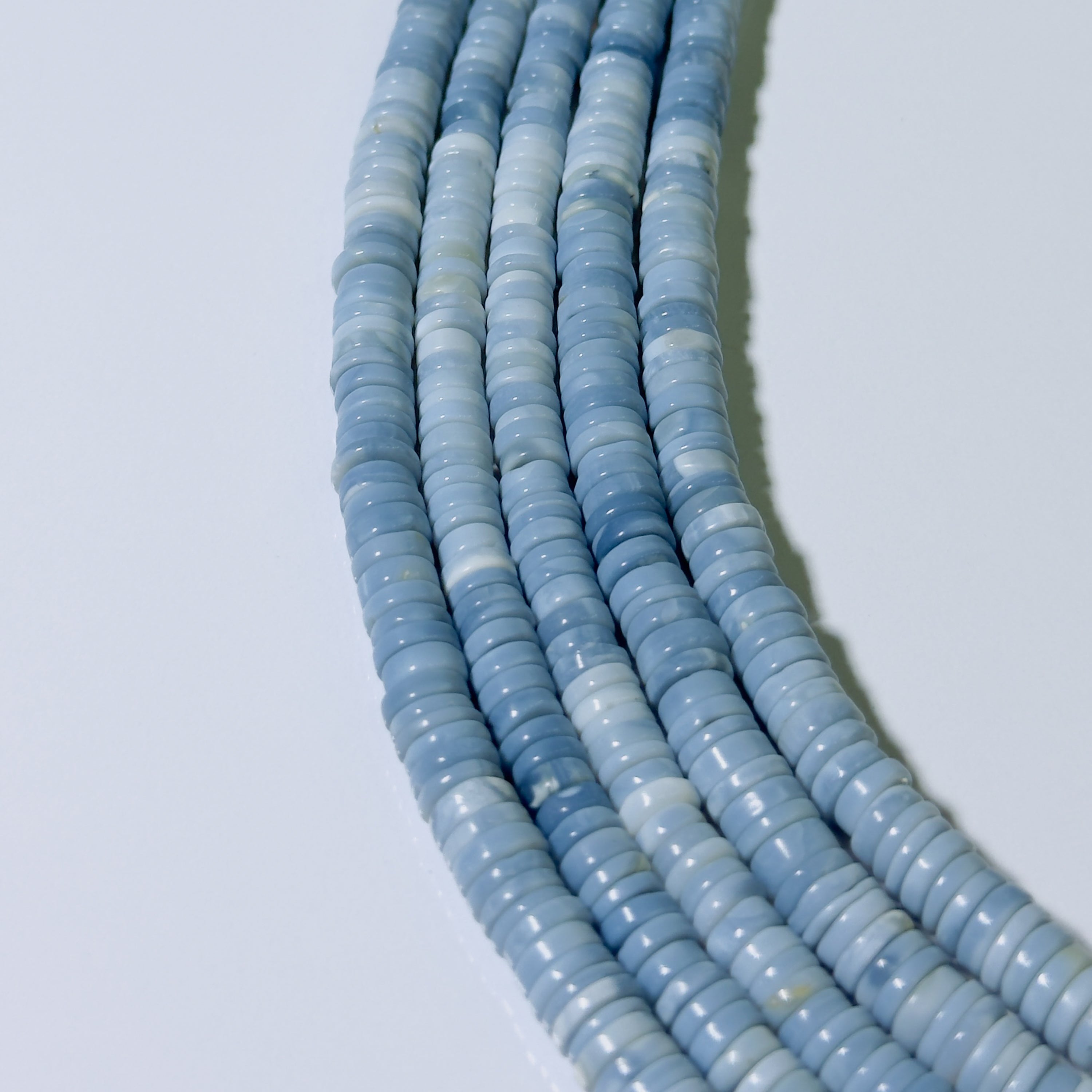String of light blue beads on a white background