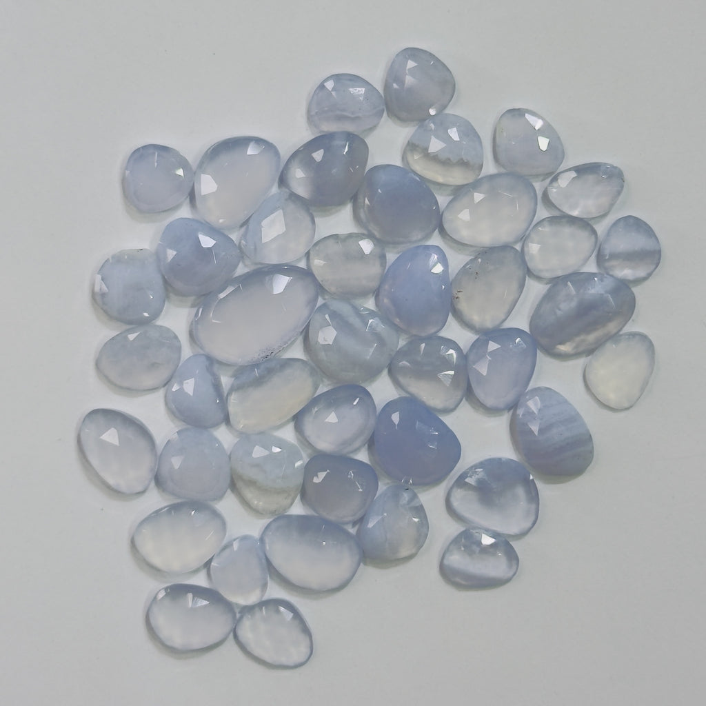 Collection of blue chalcedony stones on a light gray background