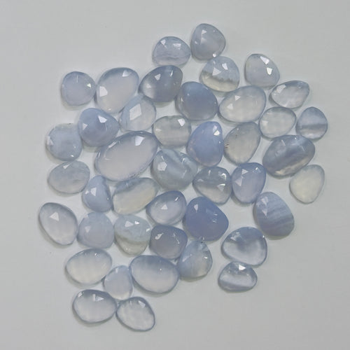 Collection of blue chalcedony stones on a light gray background