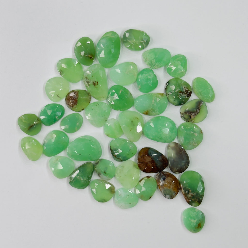 Collection of green gemstones on a white background