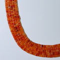 Necklace with orange beads on a light gray background