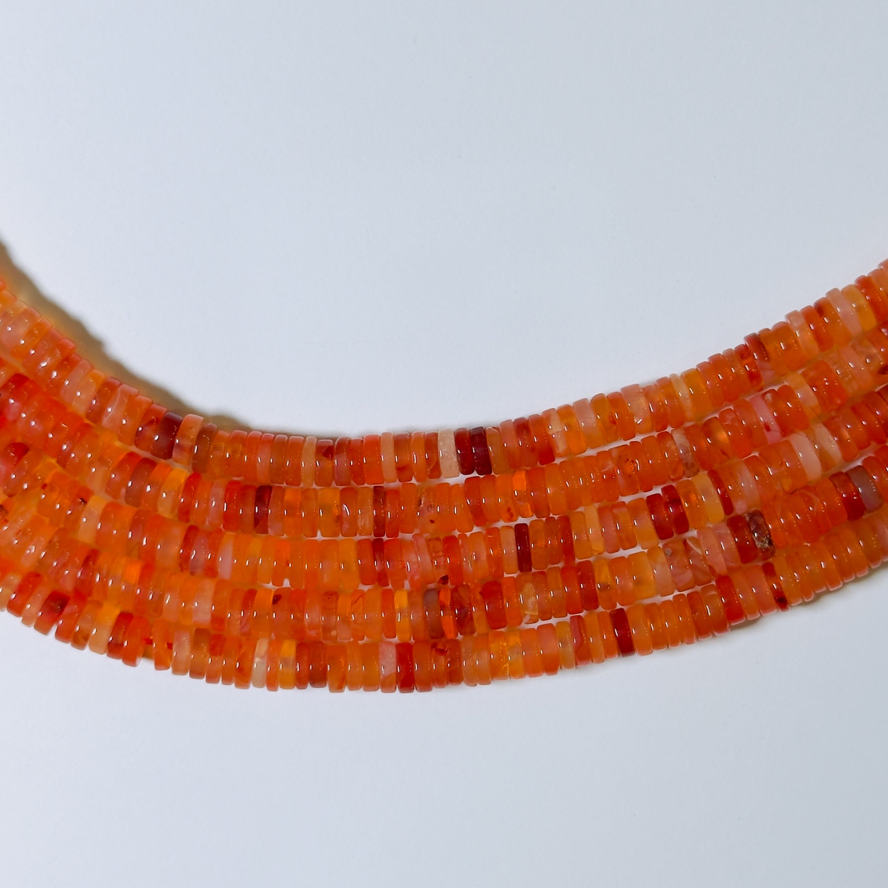 Close-up of a necklace with orange beads on a white background