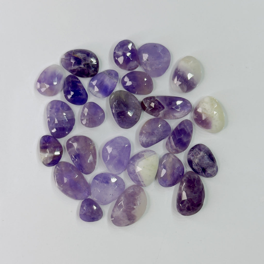 Collection of purple and white gemstones on a light gray background