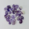 Collection of purple and white gemstones on a light gray background