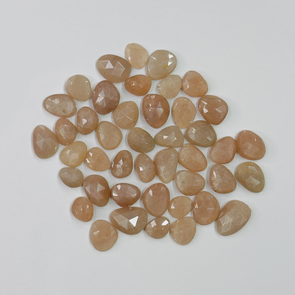 Collection of brownish-orange faceted stones on a light gray background