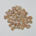 Collection of brownish-orange faceted stones on a light gray background