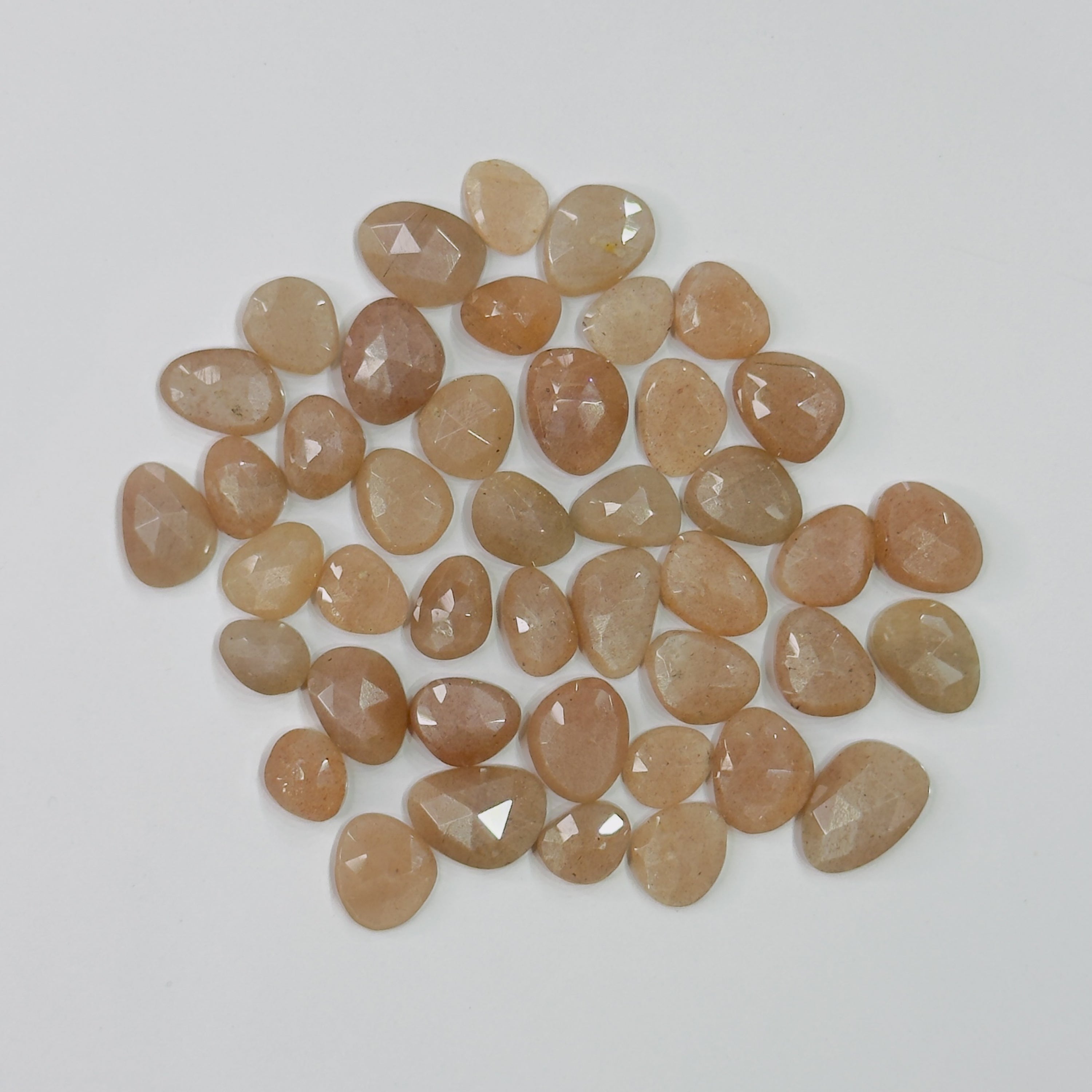 Collection of brownish-orange faceted stones on a light gray background
