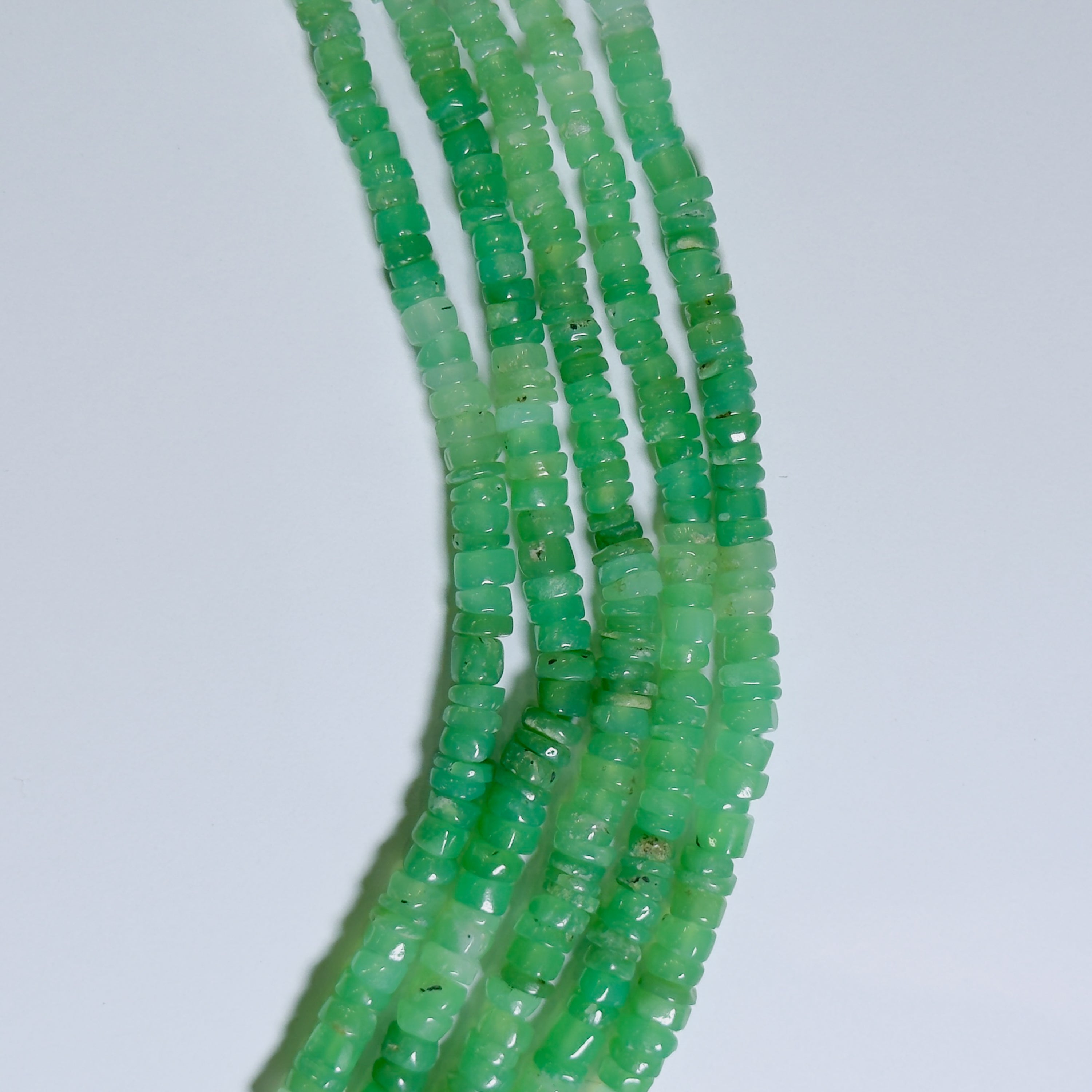 Green bead strands on a white background
