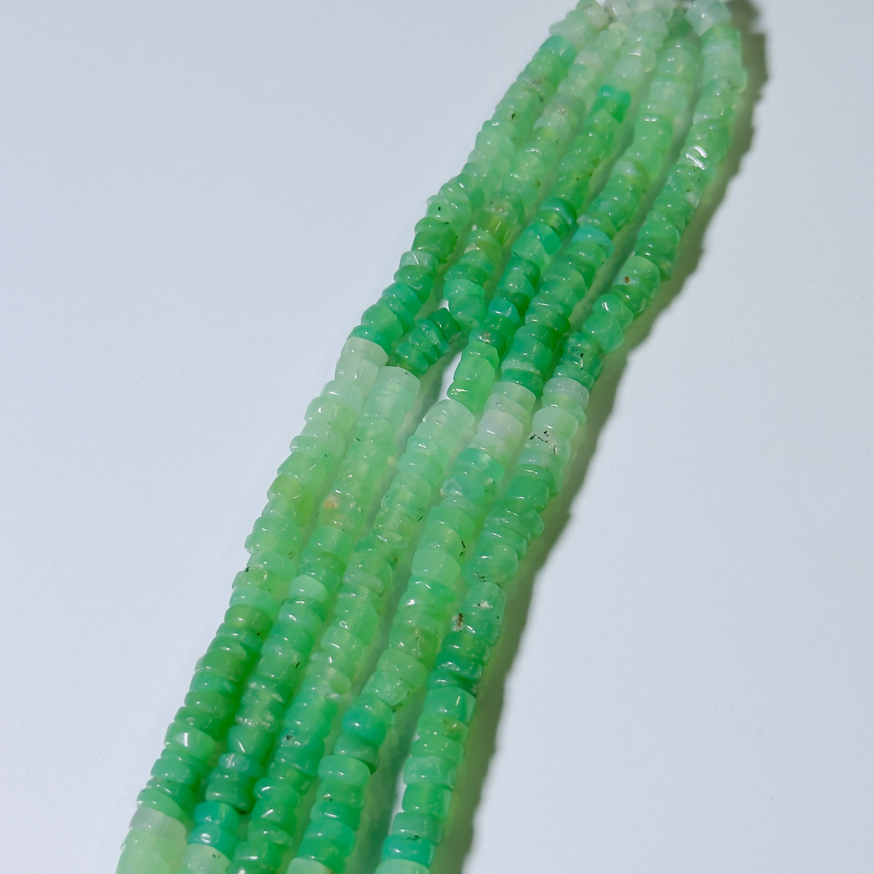 Green beaded necklace on a white background