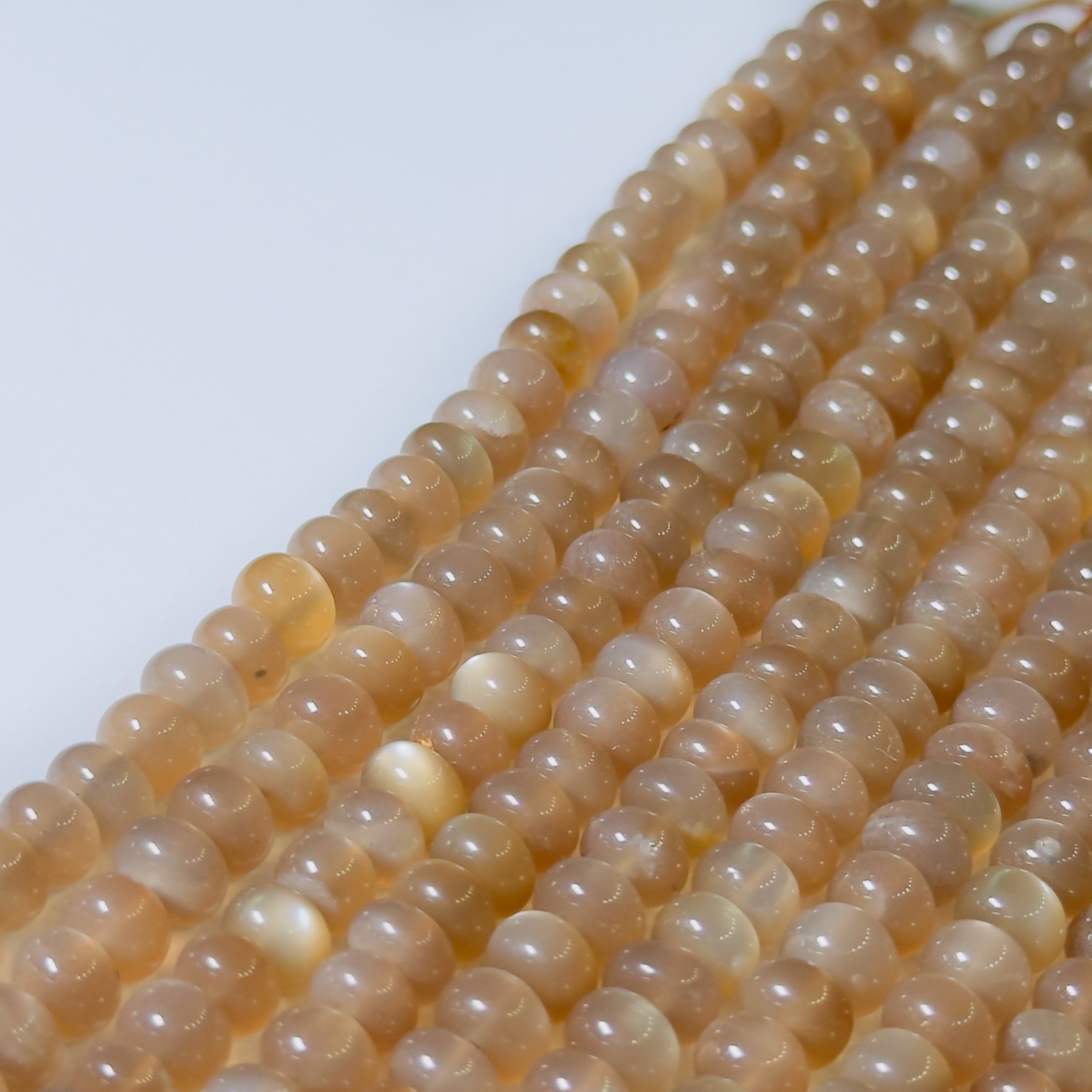 String of light brown beads on a white background