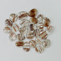 Collection of brown and clear gemstones on a white background