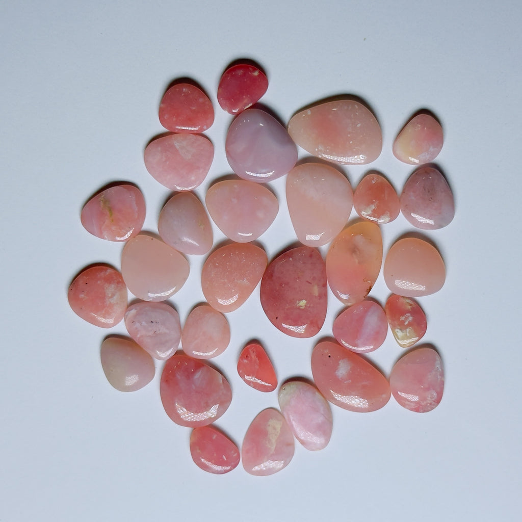 Collection of pink and peach-colored stones on a white background
