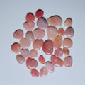 Collection of pink and peach-colored stones on a white background