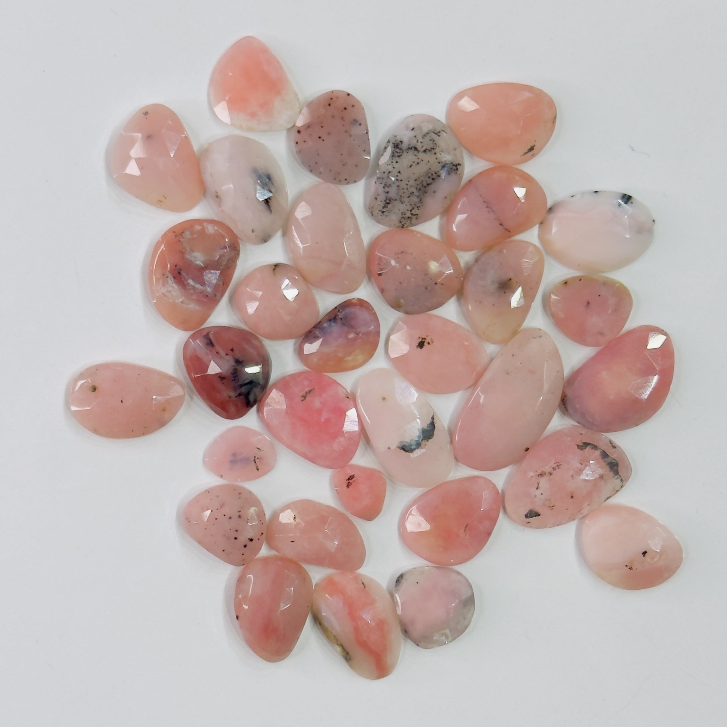 Collection of pink and red pebbles on a white background
