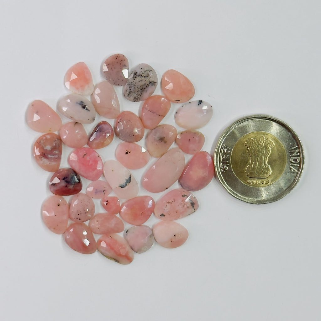 Pink stones with a coin for scale on a white background
