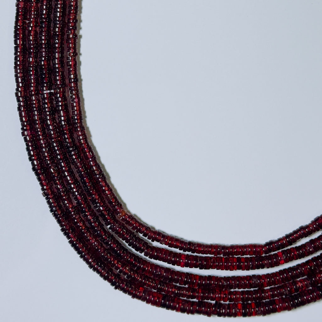 Necklace with red beads on a light gray background