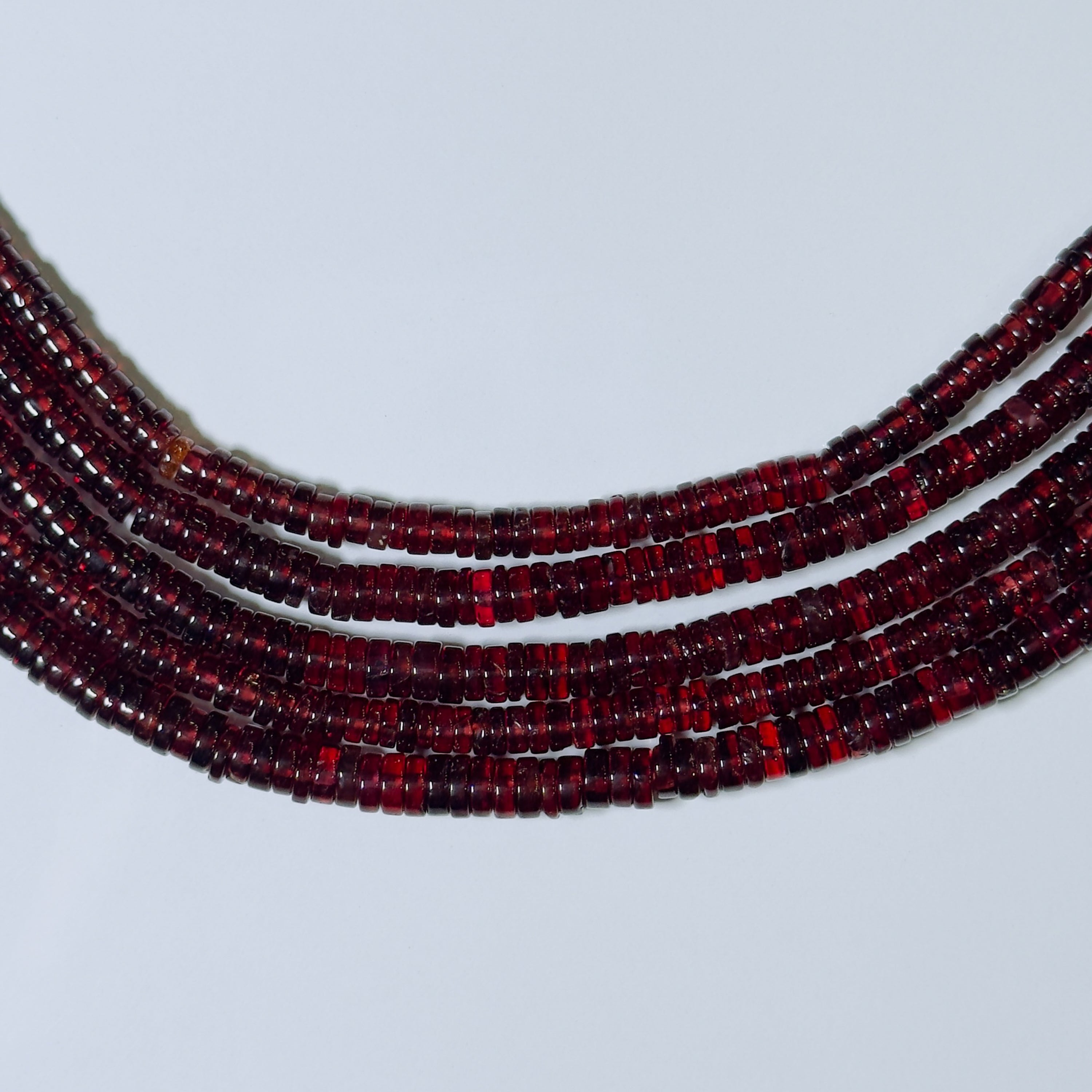 Red beaded necklace on a light gray background