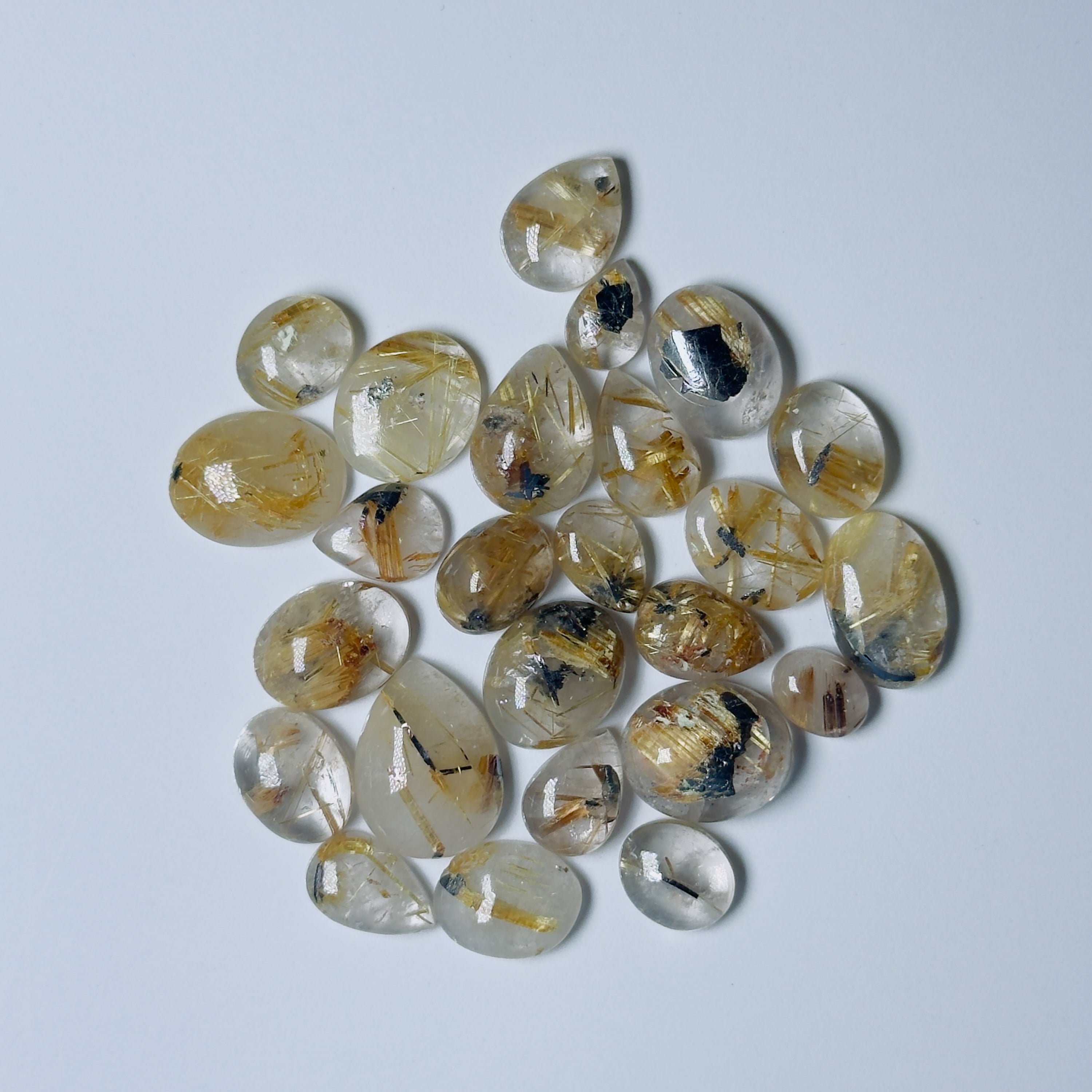 Collection of teardrop-shaped gemstones on a light gray background