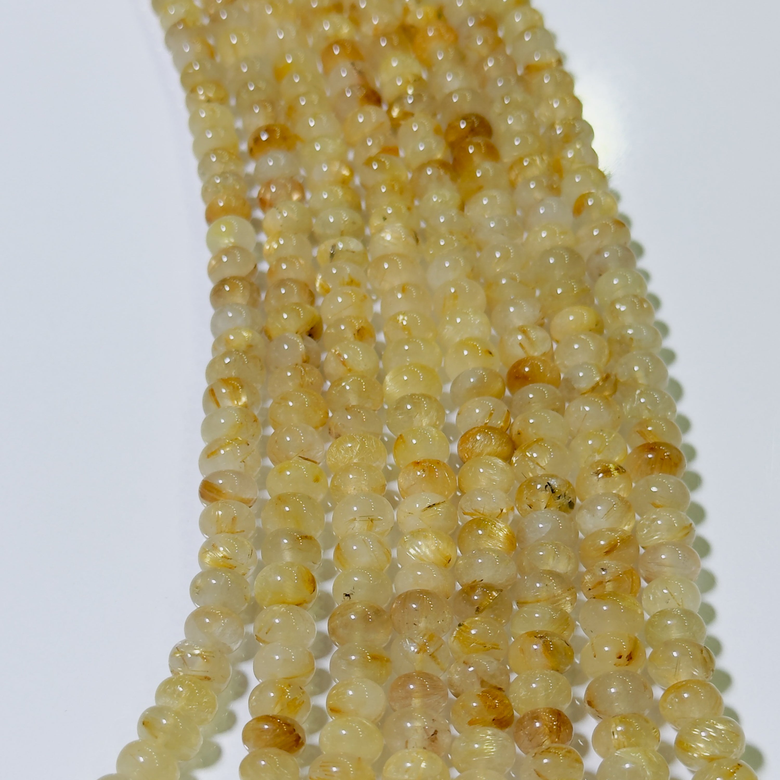 String of small yellow beads on a white background