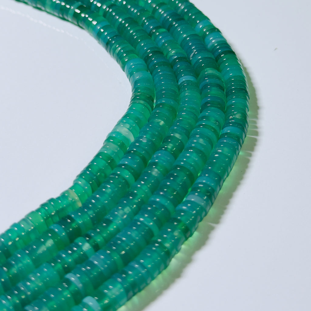 Close-up of a green beaded necklace on a white background