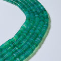 Close-up of a green beaded necklace on a white background