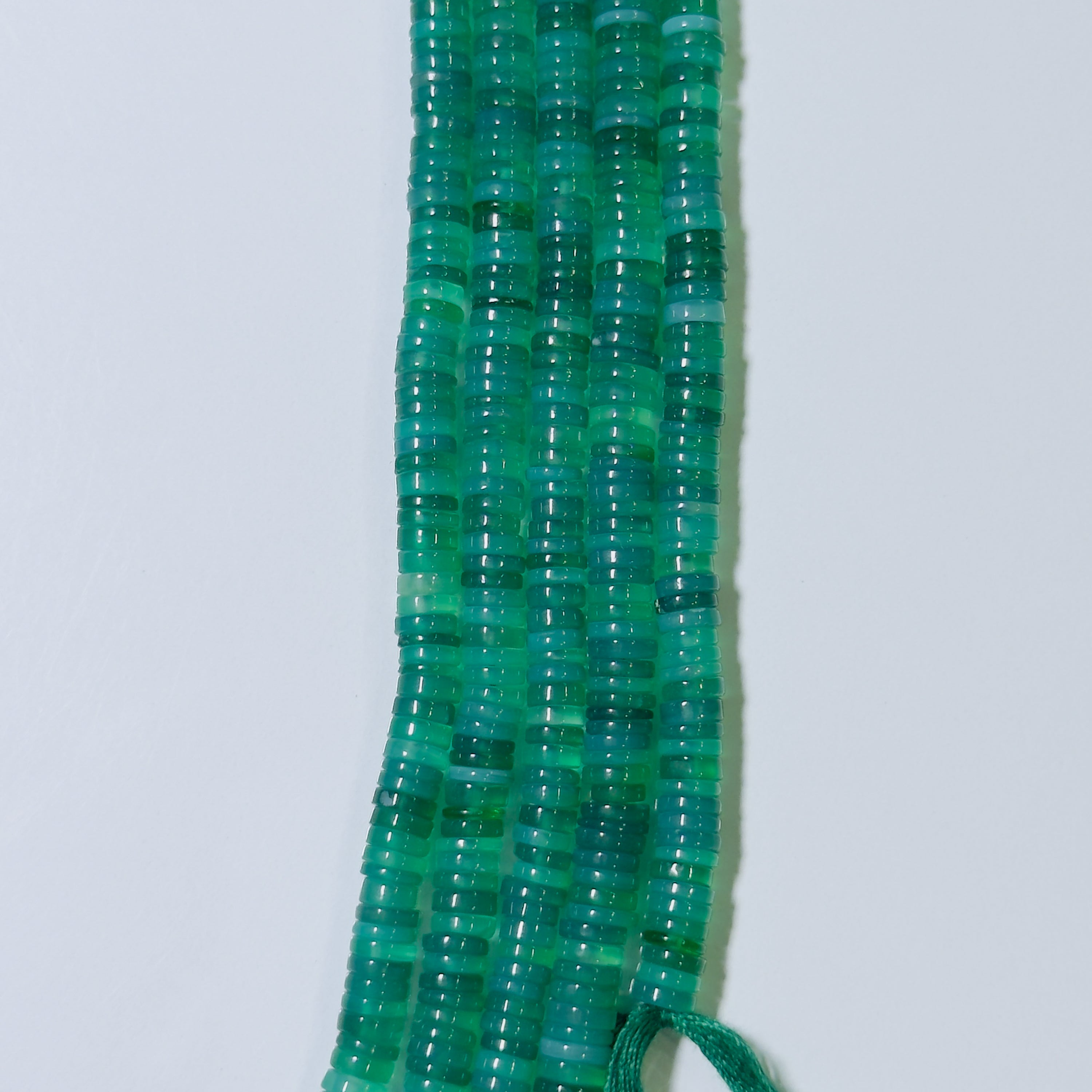Green beaded necklace on a white background