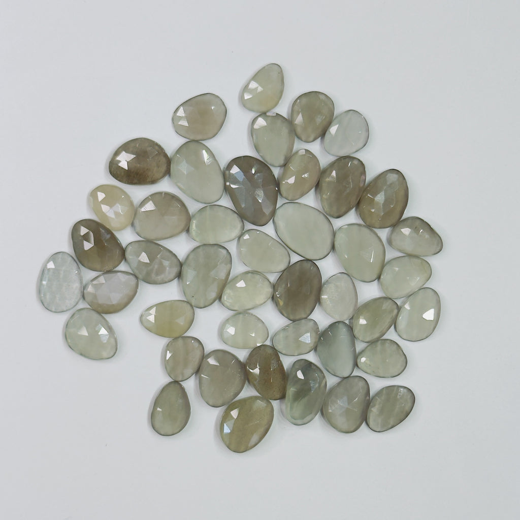 Collection of greenish-brown teardrop-shaped stones on a light gray background