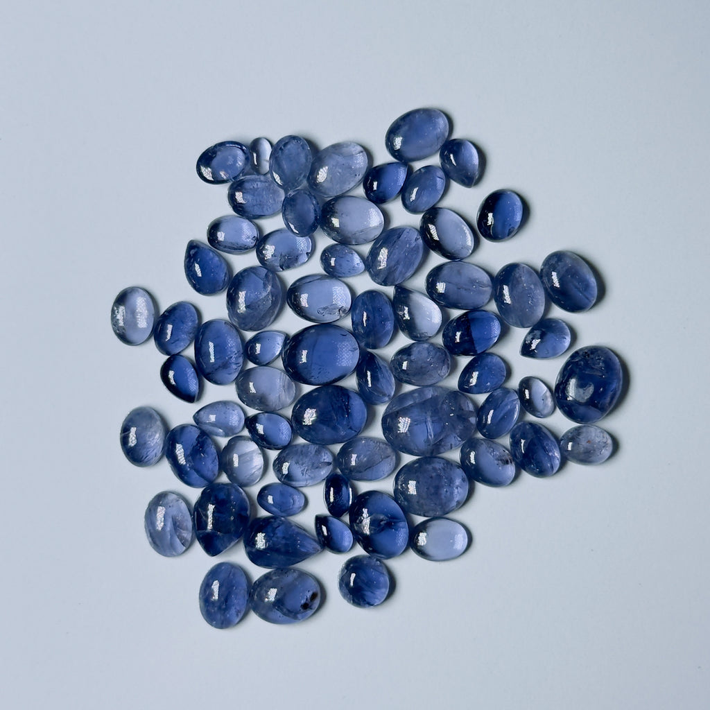Collection of blue teardrop-shaped stones on a light gray background