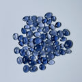 Collection of blue teardrop-shaped stones on a light gray background