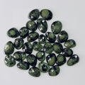 Collection of green gemstones on a white background