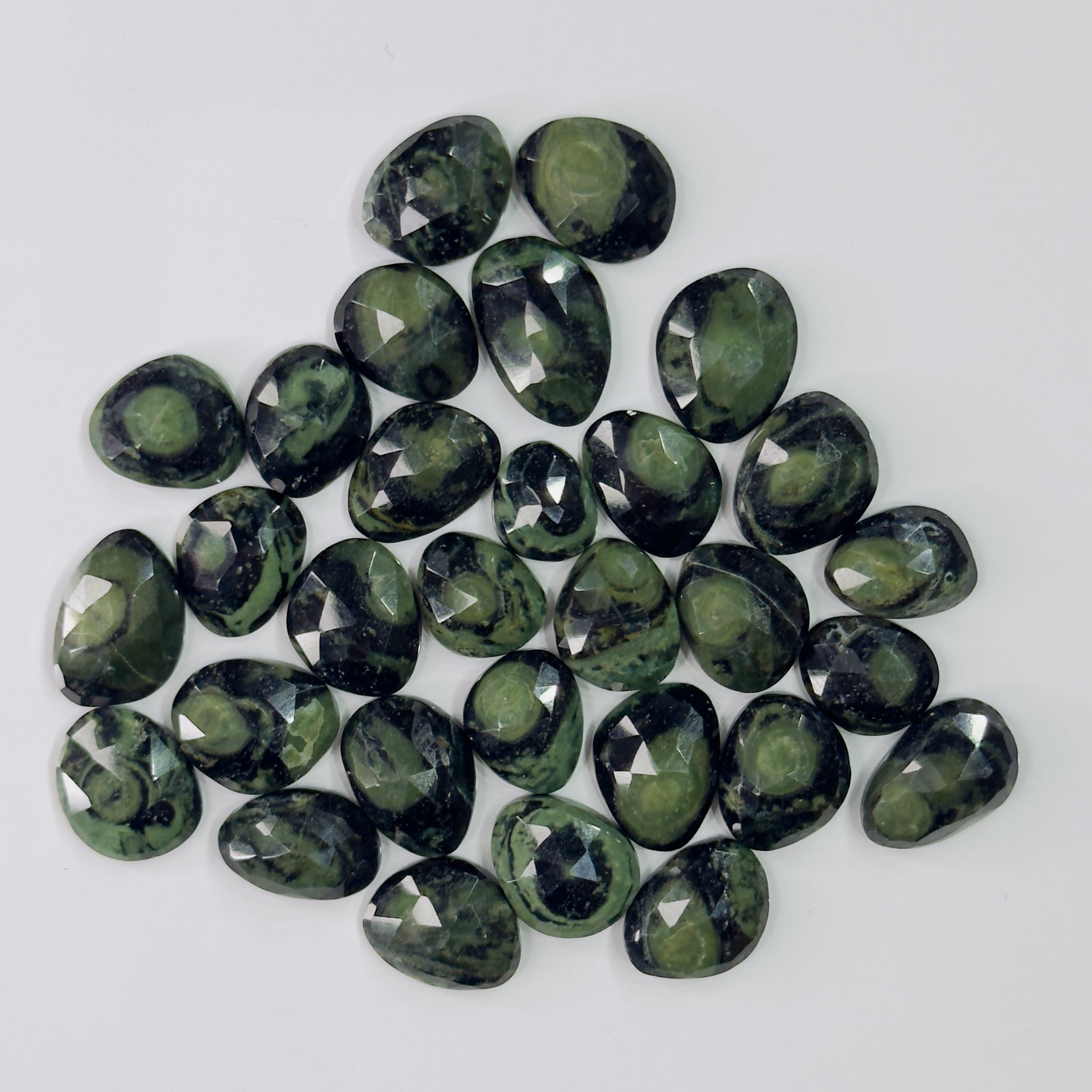 Collection of green gemstones on a white background