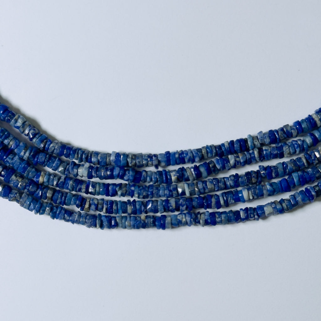 Three strands of blue beads on a light gray background