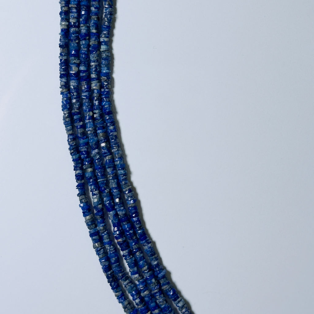 Necklace with blue beads on a light gray background
