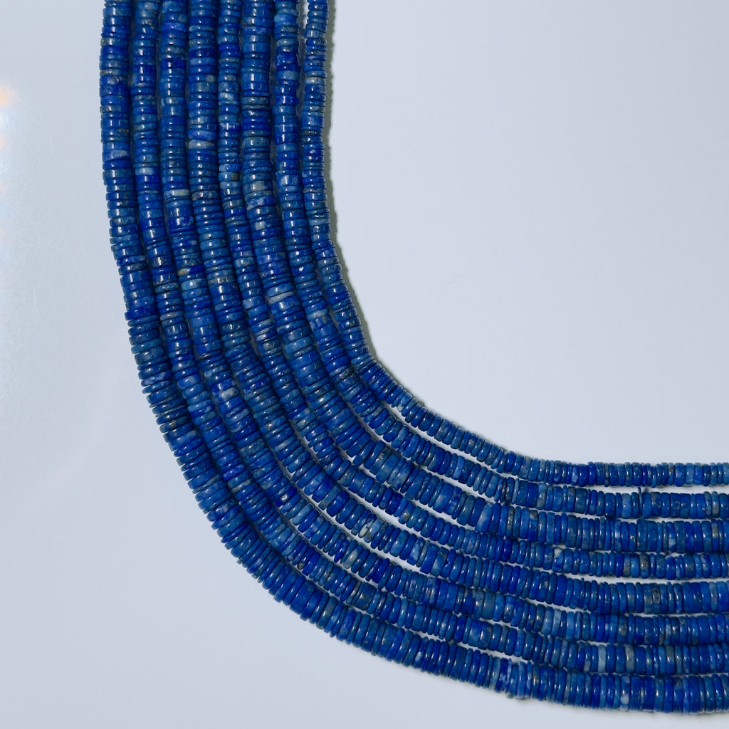 Blue beaded necklace on a light gray background